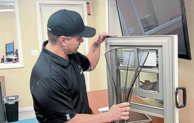 FlexScreen President Joe Altieri shows the ease of installing one of his company's flexible window screens.